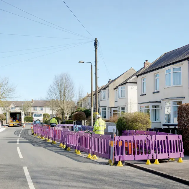 Network engineers working behind barriers on a residential street