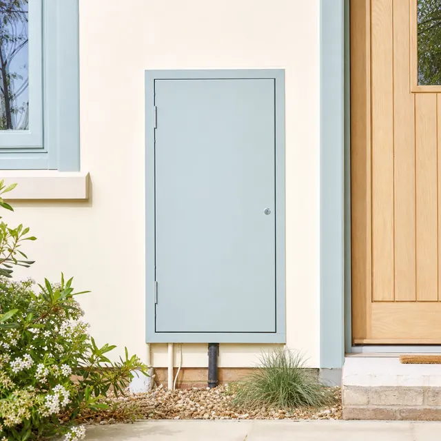 Pale blue electricity service cabinet by a front door