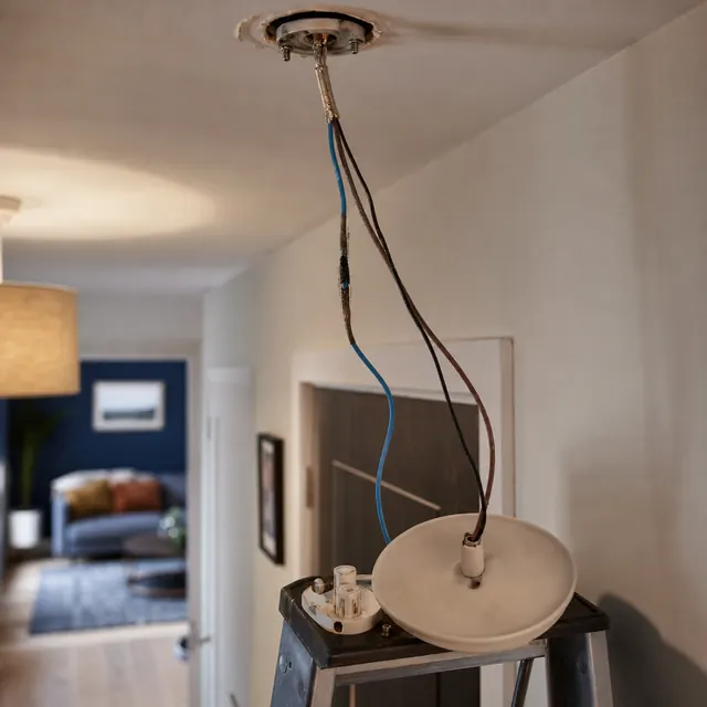 Cables running along a wall in a dim living room