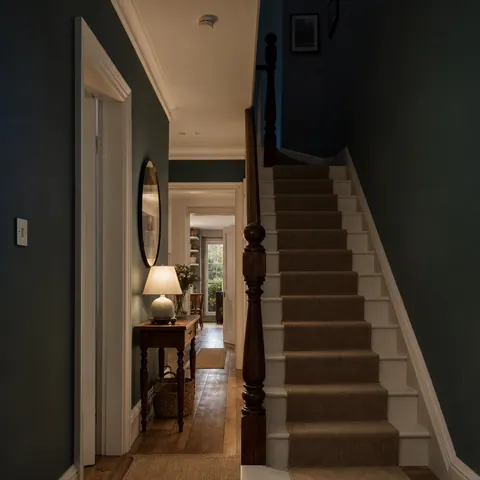 Staircase and landing lit while the ground floor is dark