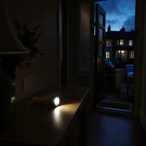 Torch beam lighting a dark hallway during a whole-house power cut
