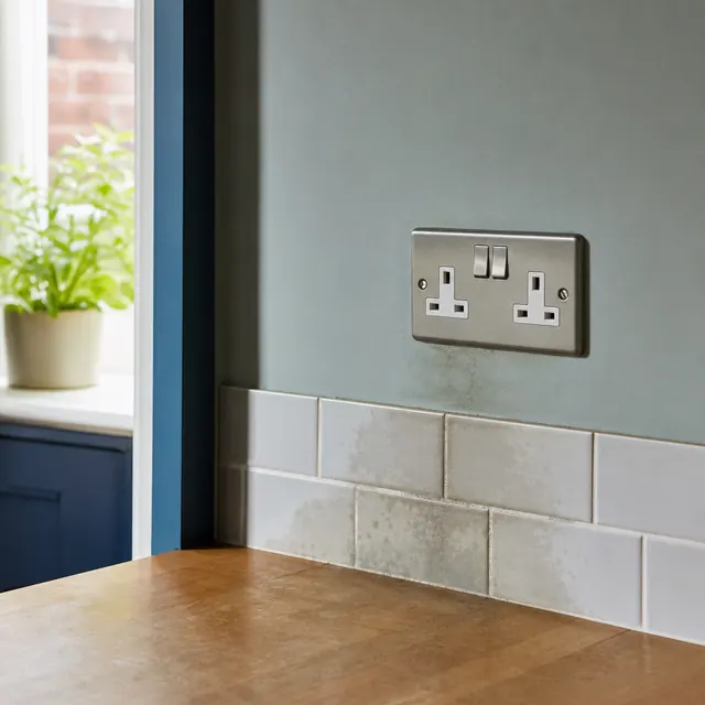 Double socket on a tiled kitchen wall near the sink