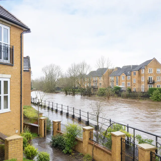 River bursting its banks beside houses after heavy rain