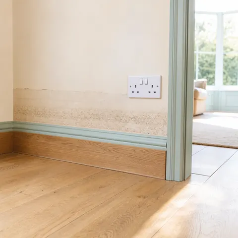 Flood water line on a wall below a socket in a hallway